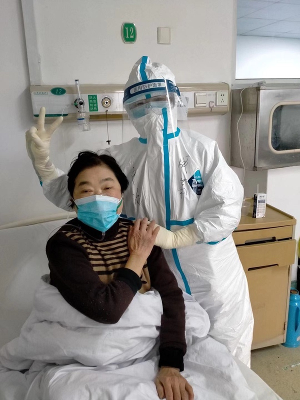 2月13日，武汉金银潭医院危重症病人区，上海援鄂医疗队员钱莉和她护理的病人在一起。.jpg